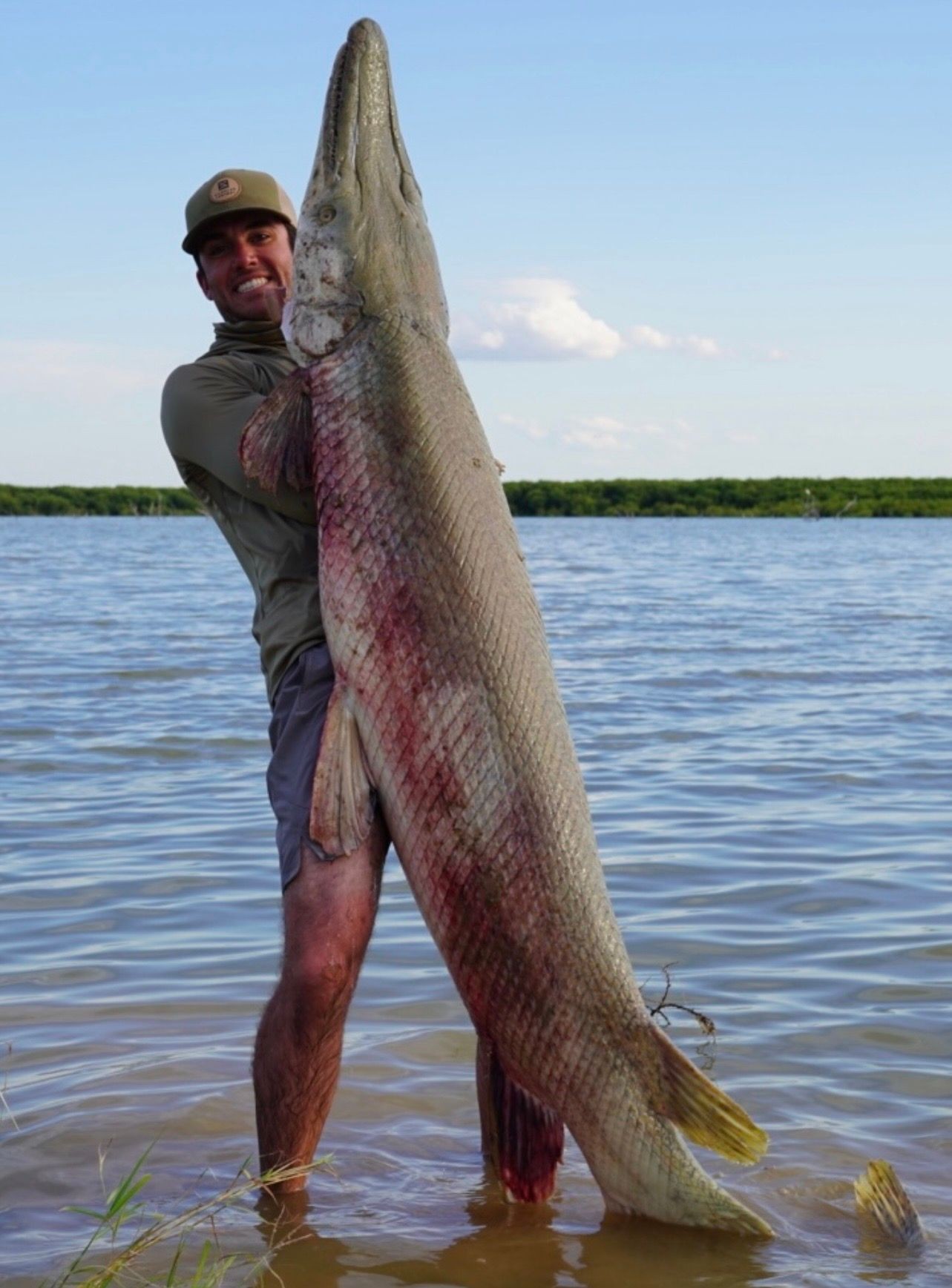 Client holding large gator gar